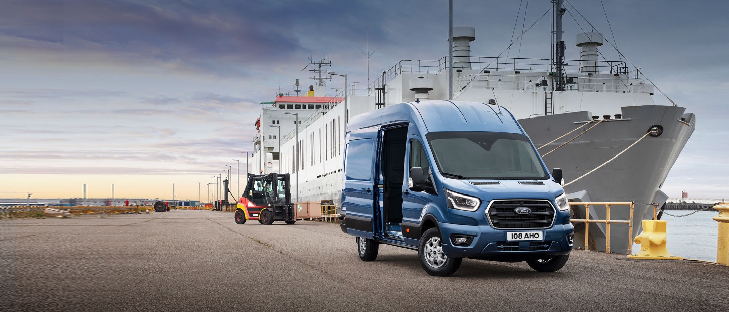 Transit Van in dock standing in front of cargo ship