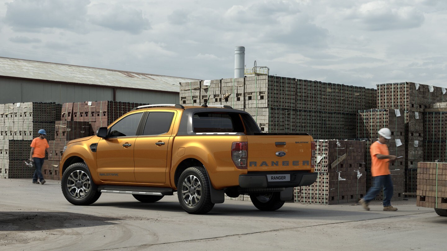 Ford Ranger naranja aparcado en un edificio de construcción