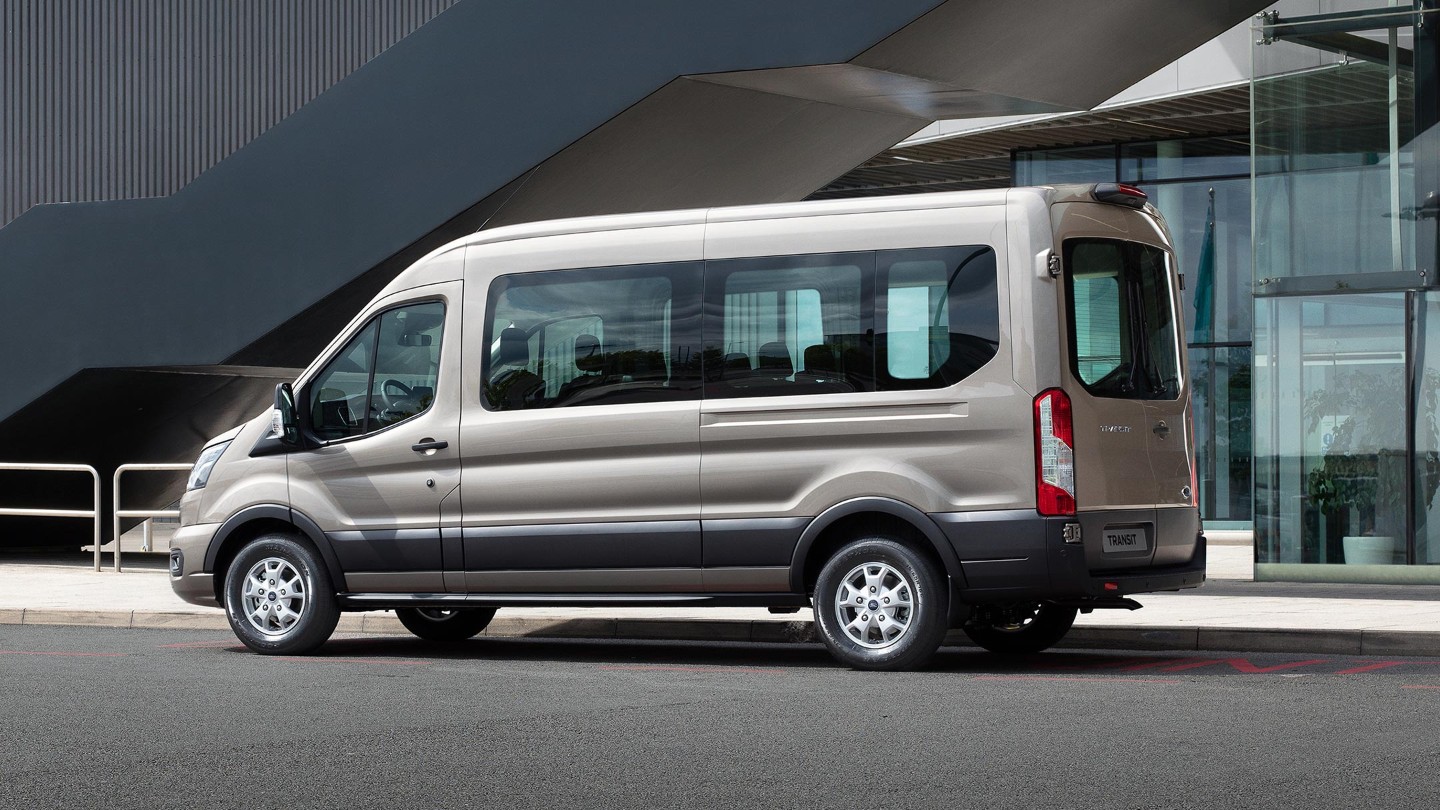 Vista lateral de la Ford Transit Kombi aparcada al lado de un edificio moderno 