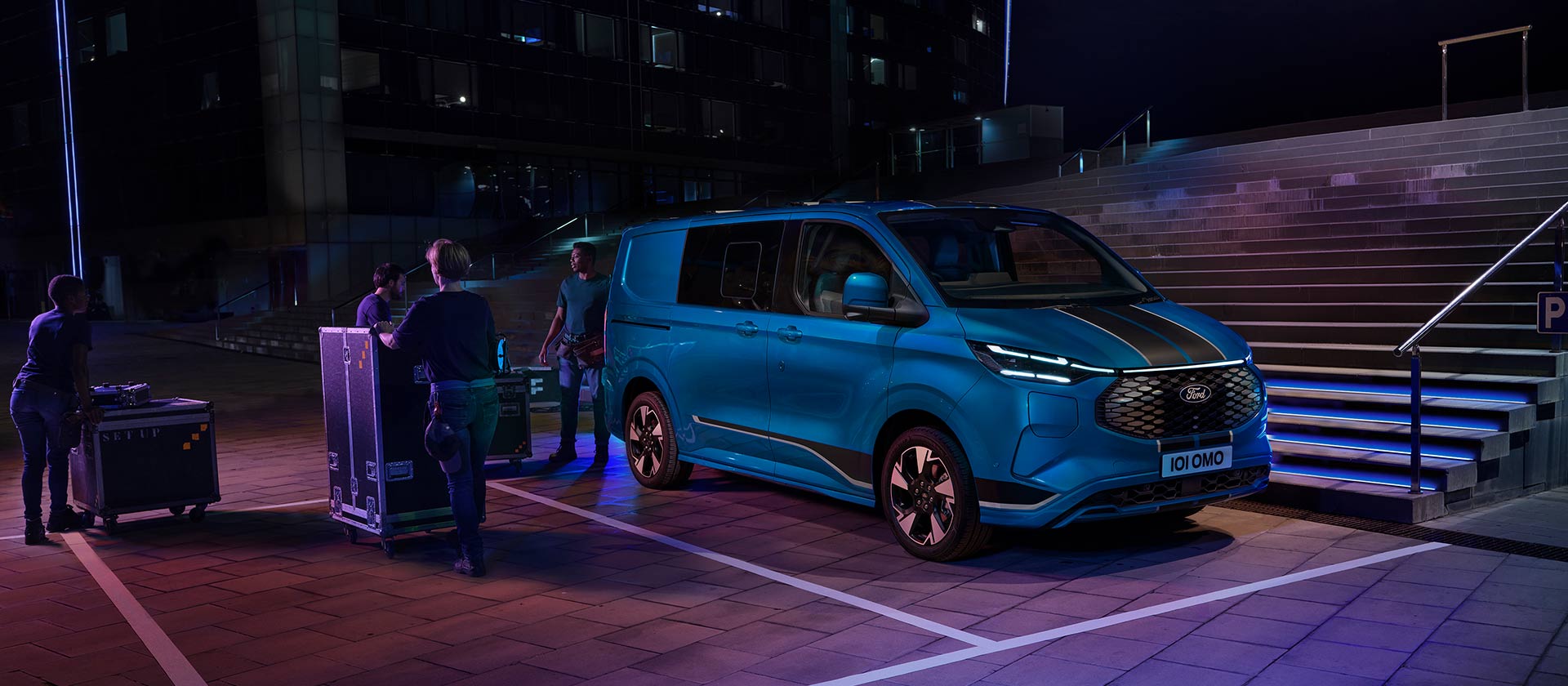 Una furgoneta eléctrica Ford E-Transit Custom azul cargando por la noche.