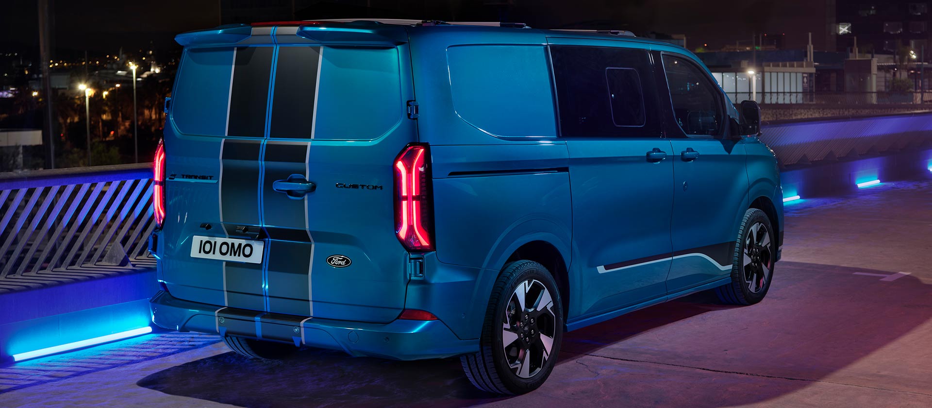 Vista trasera de una Ford E-Transit Custom Sport eléctrica azul con doble cabina.