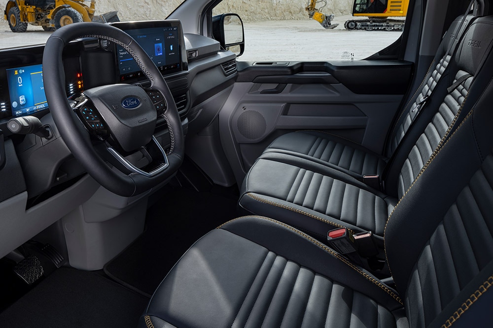 Interior de una furgoneta eléctrica Ford E-Transit Custom Sport con asientos negros y dorados.