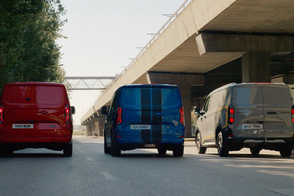 Tres furgonetas Ford Transit Custom circulando por una autopista.