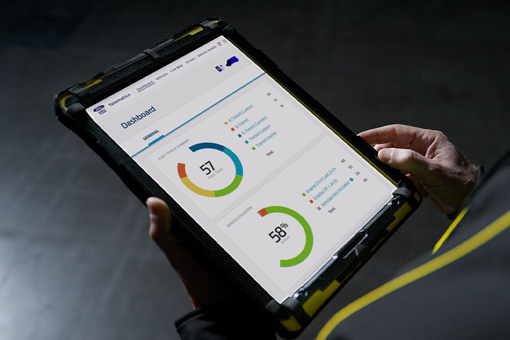 Una persona sostiene una tableta que muestra los datos del vehículo en Ford Pro.