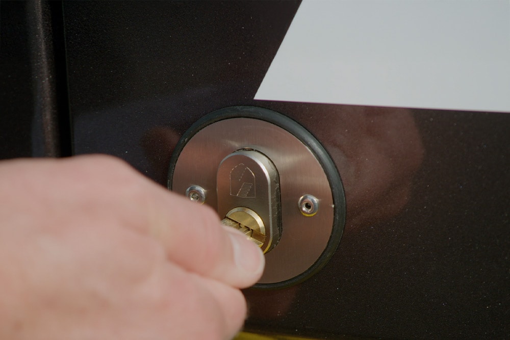 Una mano cerrando la puerta de una furgoneta con una llave.