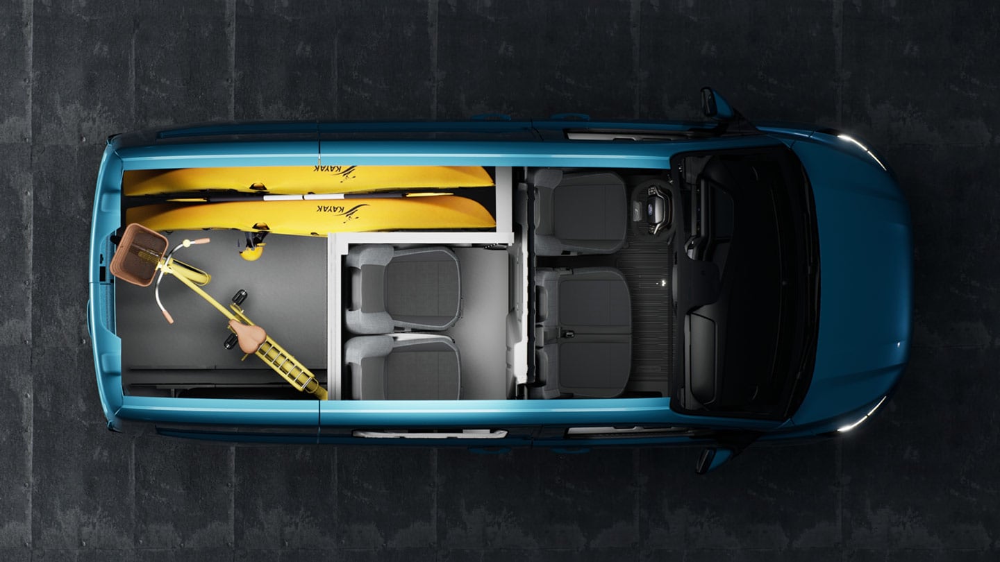 Interior de una Ford E-Transit Custom con un kayak y bicicletas.
