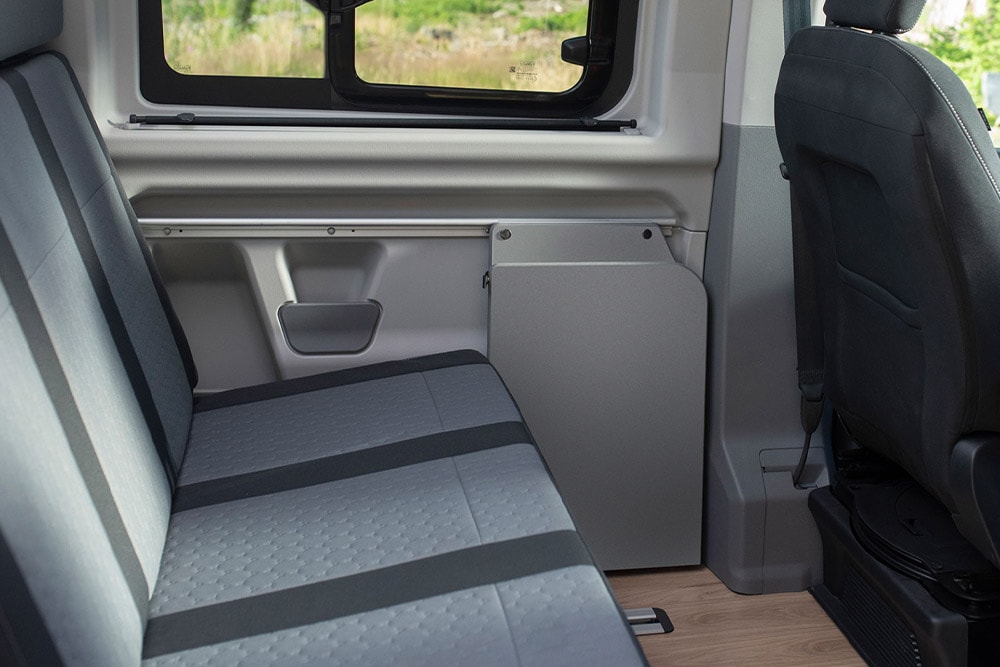 Segunda fila de asientos grises, calefactados y adaptables de una Ford Transit Custom Nugget.