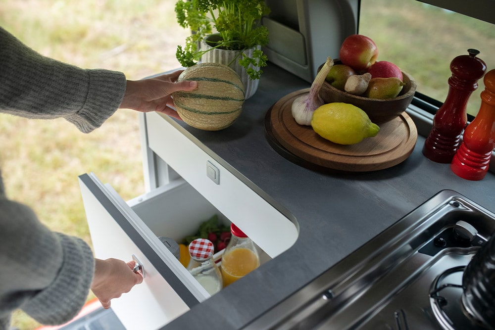 Nevera estilo cajón de 33 litros de la Ford Transit Custom Nugget, con fruta en la encimera.