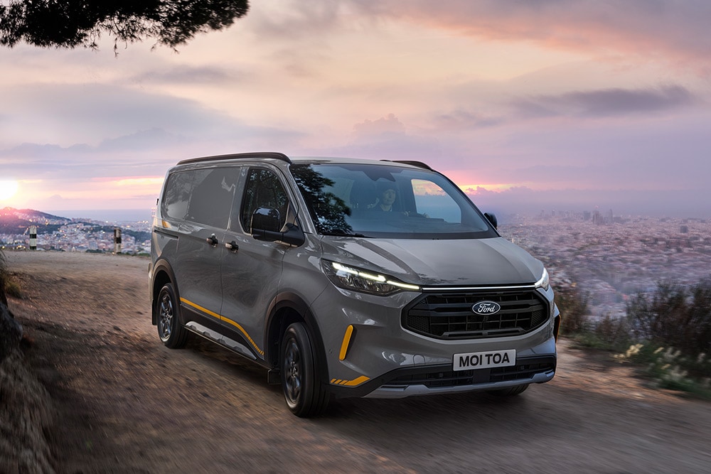 Furgoneta Ford Transit Custom Trail gris con detalles en amarillo.