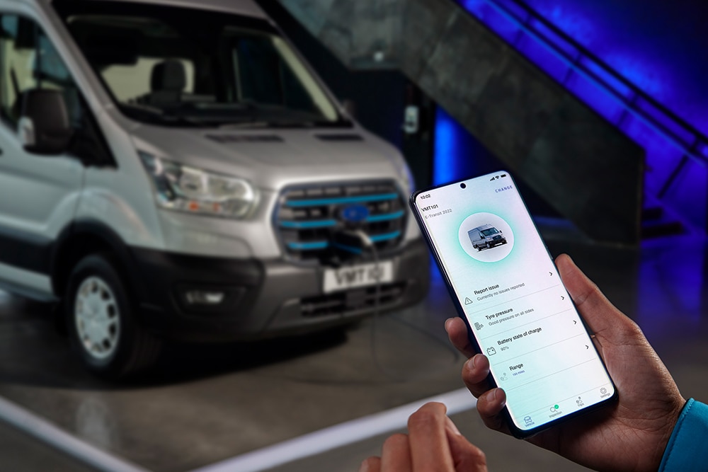 Teléfono móvil con aplicación abierta y una E-Transit de fondo