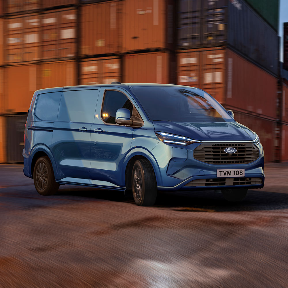 Blue Ford Transit Custom Plug-in Hybrid van drives through a dockyard.