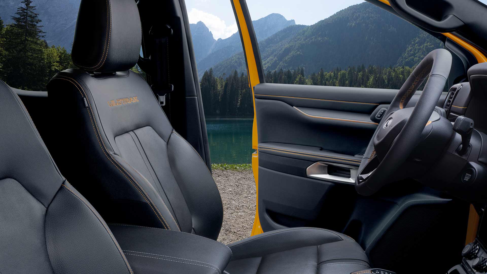 Vista interior de un Ford Ranger Wildtrak con asientos de cuero negro y la palabra «Wildtrak» bordada en amarillo.