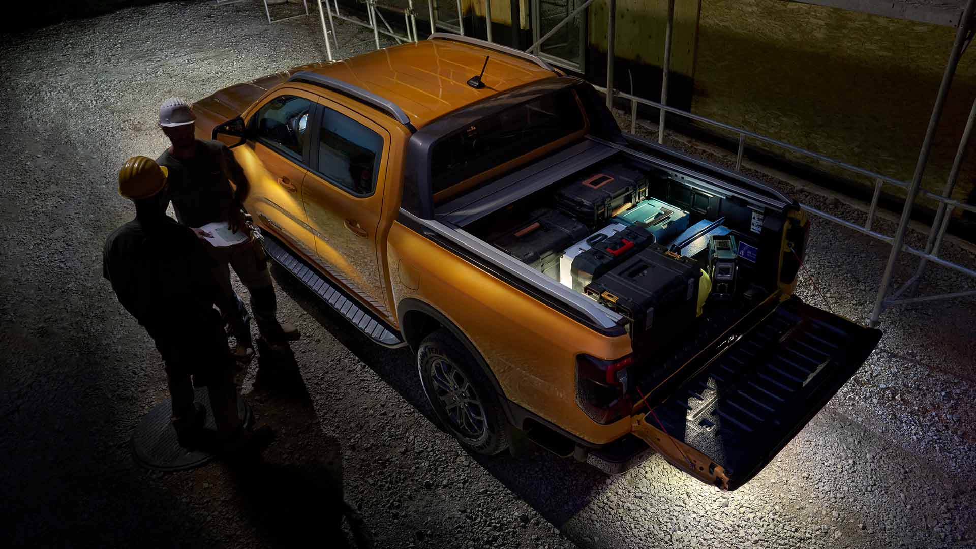 Vista superior de un Ford Ranger Wildtrak amarillo por la noche con la iluminación zonal activada.