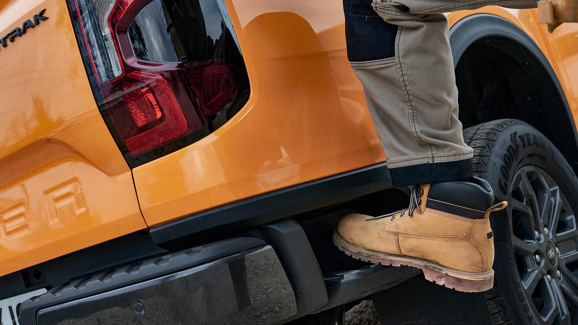 Trabajador subiendo al escalón trasero integrado del Ford Ranger.