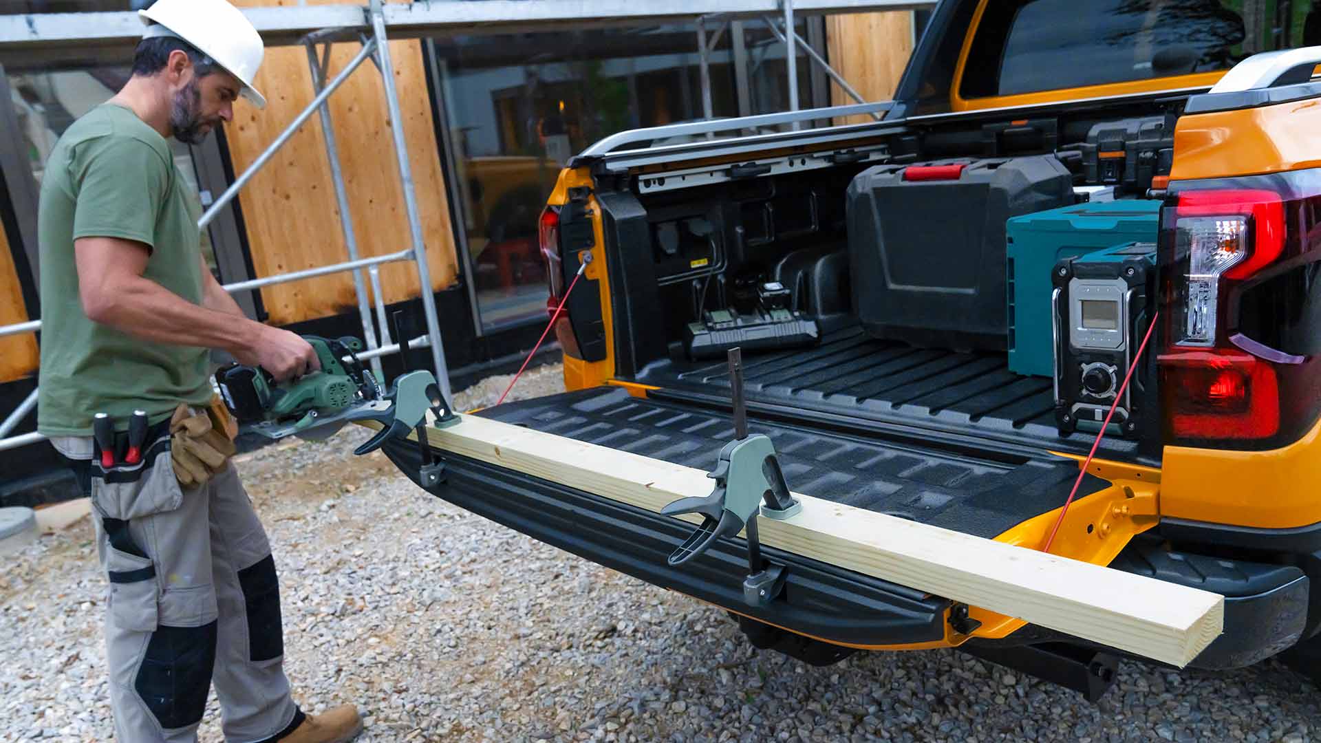 Trabajador utilizando el portón trasero del Ford Ranger Wildtrak como banco de trabajo.