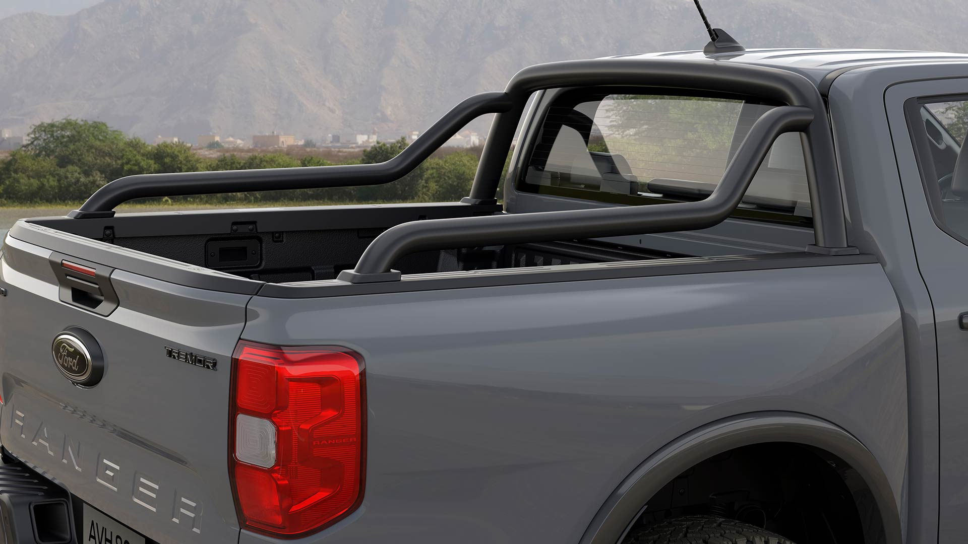 Parte trasera de un Ford Ranger con doble cabina gris con barras deportivas.
