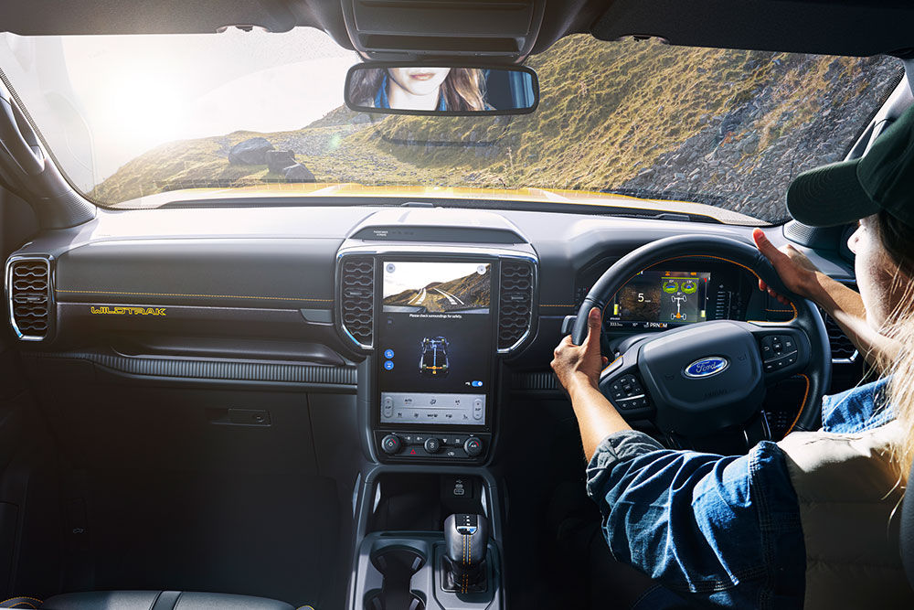 Imagen de un conductor sujetando el volante de un Ford Ranger mientras recorre una sinuosa pista de montaña.