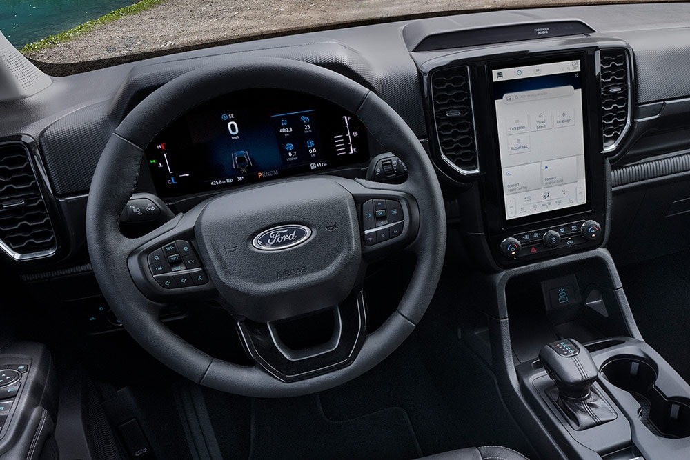 Interior view of a Ford Ranger Super Cab, focusing on the steering wheel and dashboard.