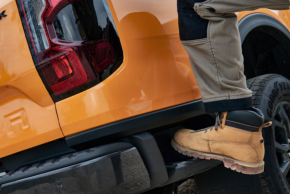 Trabajador subiendo al escalón trasero integrado del Ford Ranger Wildtrak.