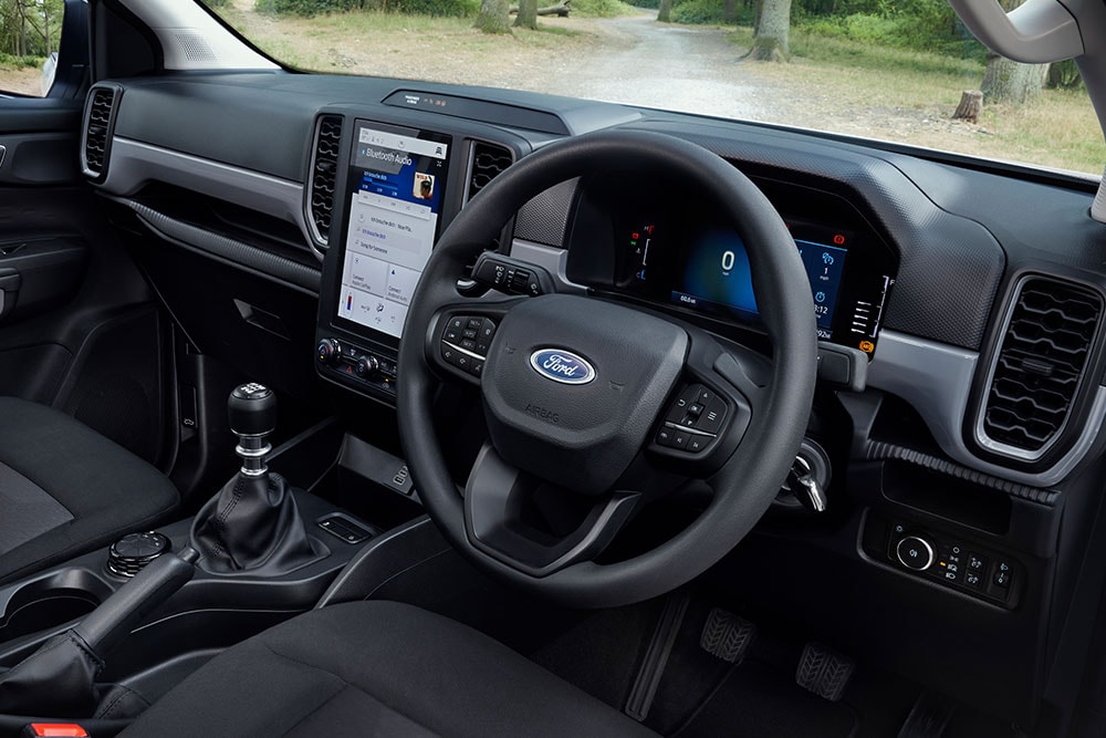 Vista interior de la cabina de un Ford Ranger que muestra el volante y la palanca de cambios manual.