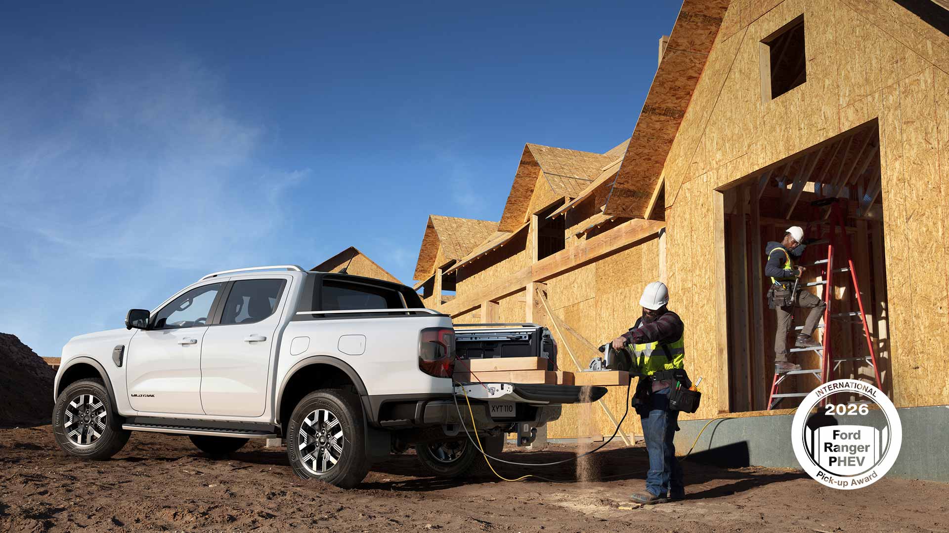 Ford Ranger blanco aparcado en una obra, con una sierra enchufada mientras un obrero corta madera