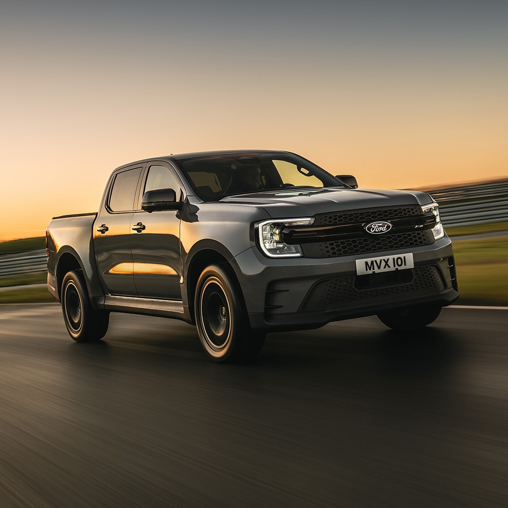 Un Ford Ranger MS-RT gris recorre una pista al atardecer.
