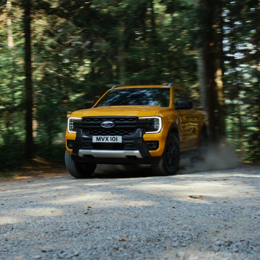 Vídeo de un Ford Ranger Wildtrak con cabina doble amarillo que recorre carreteras de montaña y senderos de grava.