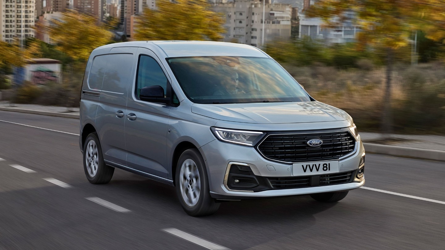 La nueva Ford Transit Connect Limited en Stardust Silver circula por una carretera con bordes exteriores cromados y faros automáticos.