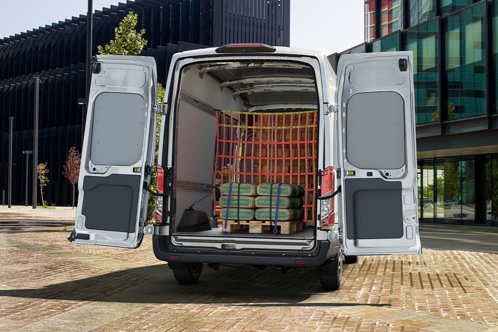 Furgoneta Ford Transit de doble cabina con las puertas traseras abiertas y carga en el interior.
