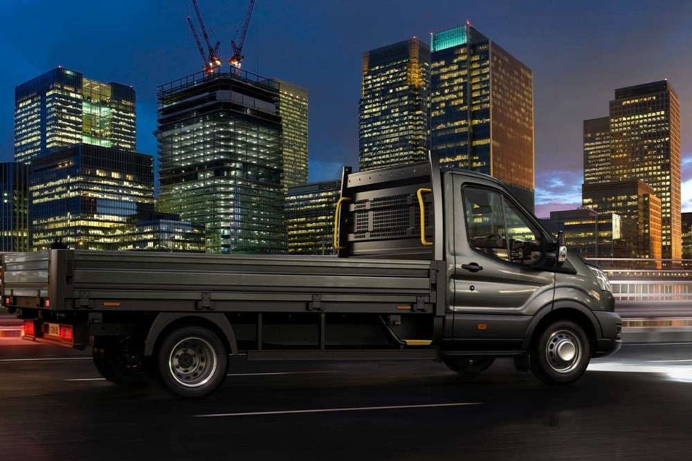 Una Ford Transit Chassis Cabina recorre una carretera urbana por la noche.