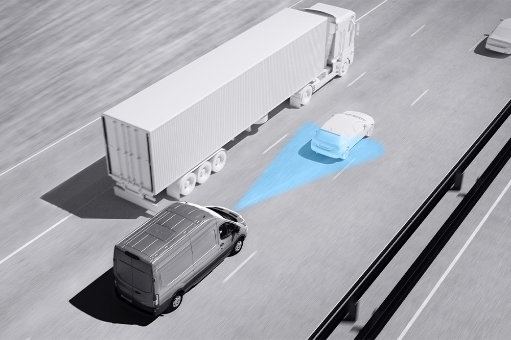 Dibujo en escala de grises de una furgoneta Ford Transit con líneas azules en la carretera que representa el uso de los sistemas avanzados de asistencia al conductor (ADAS).