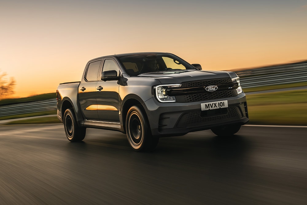 Una Ford Ranger Platinum gris oscuro circula por una pista al atardecer.