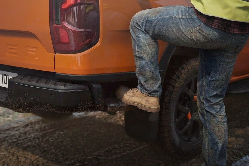 Trabajador subiendo el escalón trasero integrado de la Ford Ranger Wildtrak.