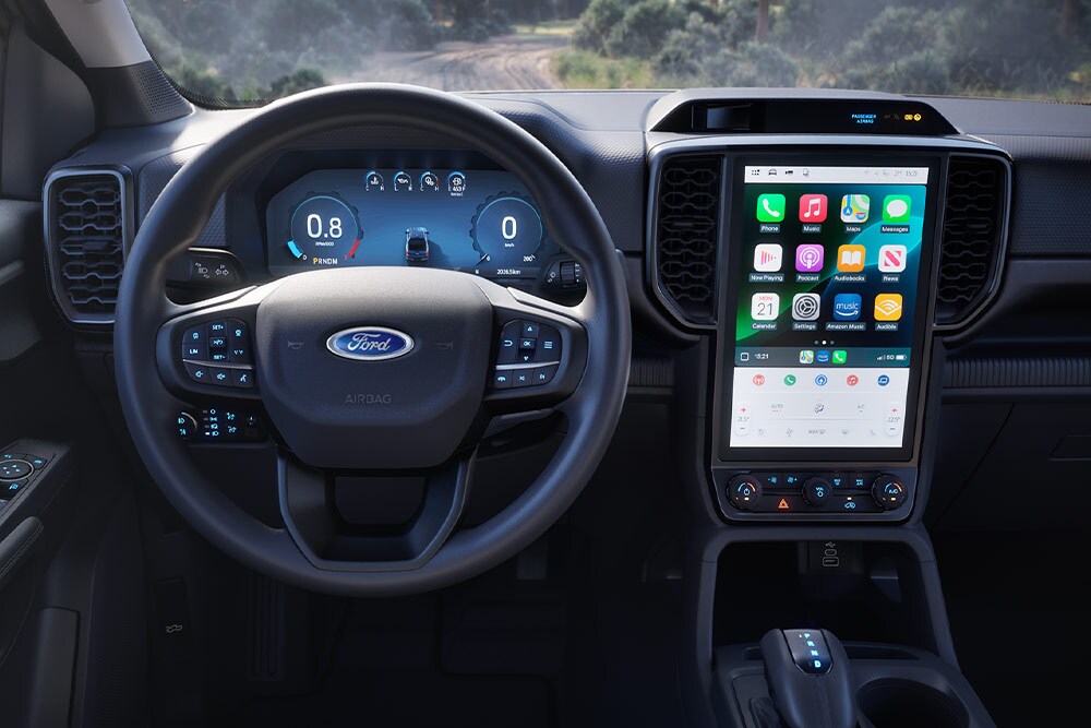 Vista del interior de una Ford Ranger Super Cab centrada en el volante, el salpicadero y la pantalla de infoentretenimiento.