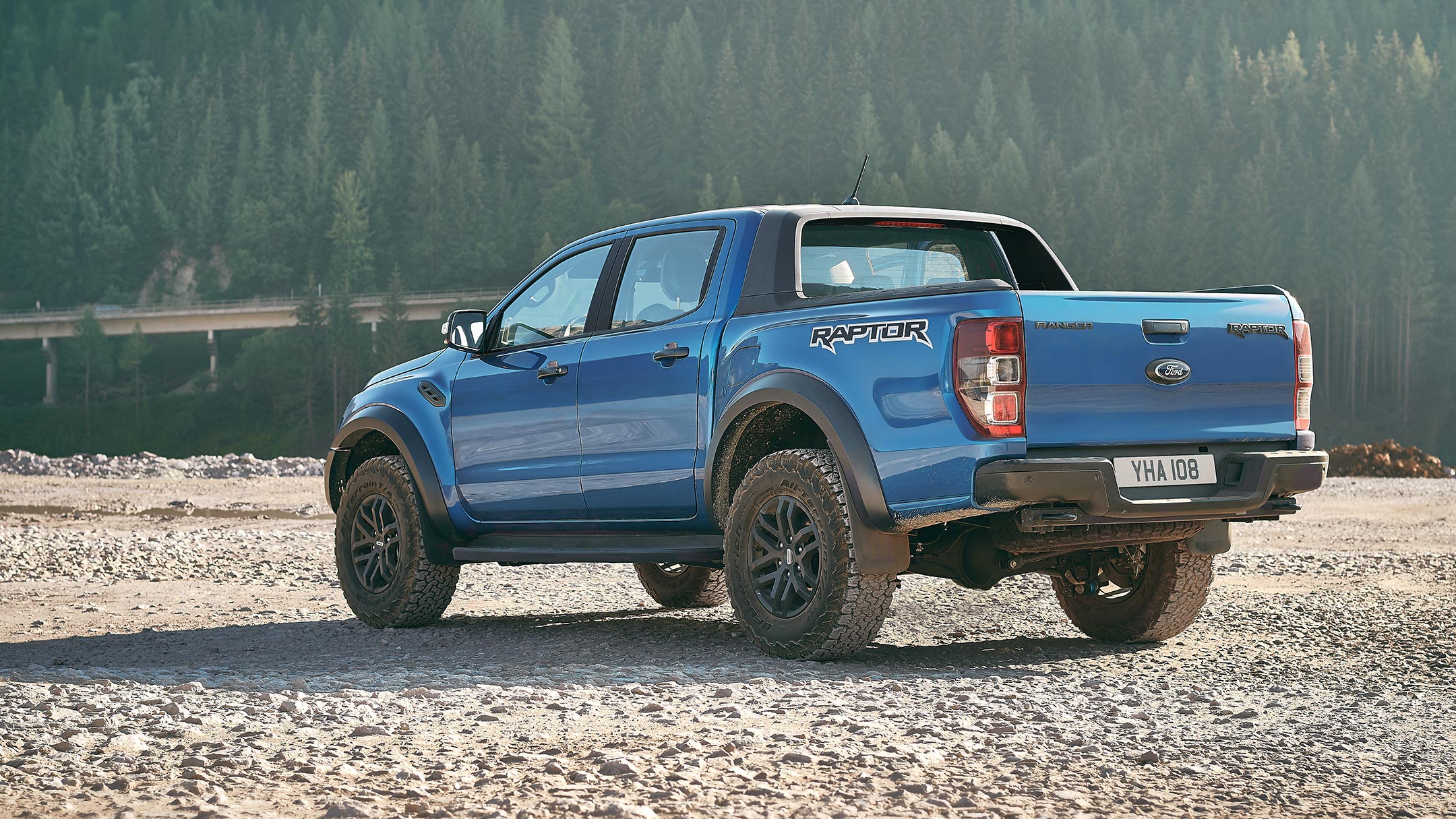 Ford Ranger Raptor en color azul Ford Performance aparcada cerca de un bosque