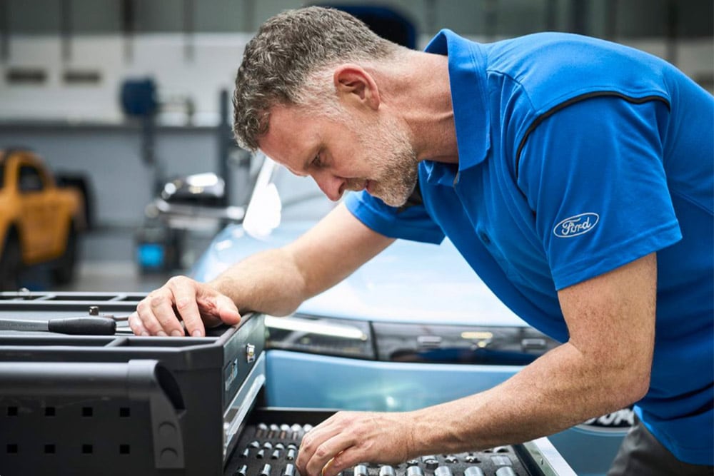 Primer plano de un técnico autorizado por Ford trabajando en un taller.