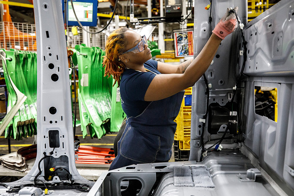  Mecánico de Ford trabajando en una furgoneta en un garaje.