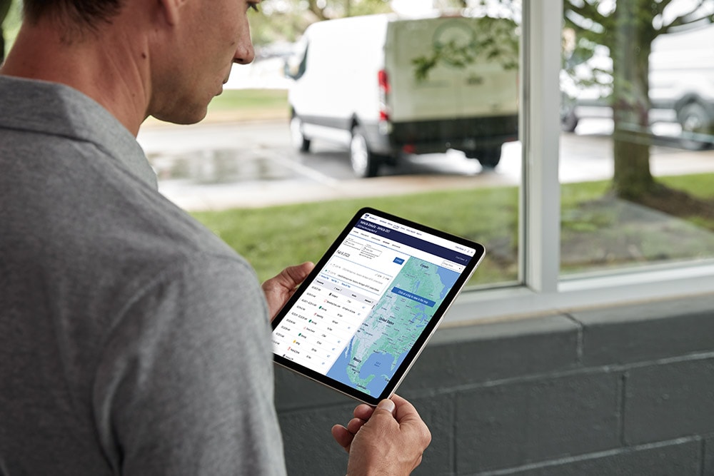 Hombre mirando los datos de su vehículo Ford en una tablet, monitoreándolos en vivo.