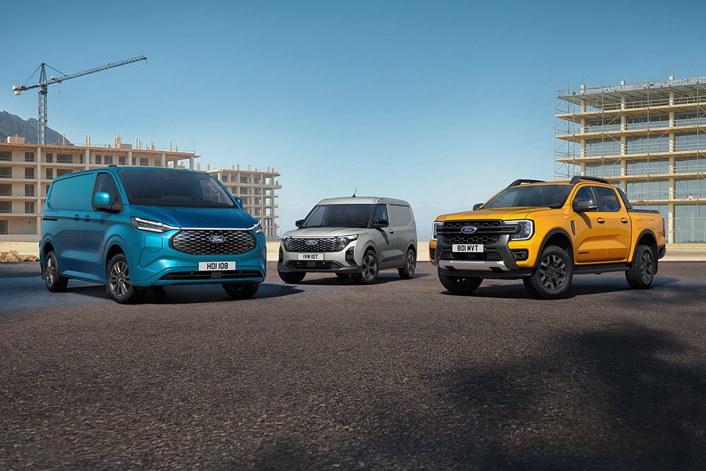 Una colección de vehículos Ford aparcados frente a una obra.