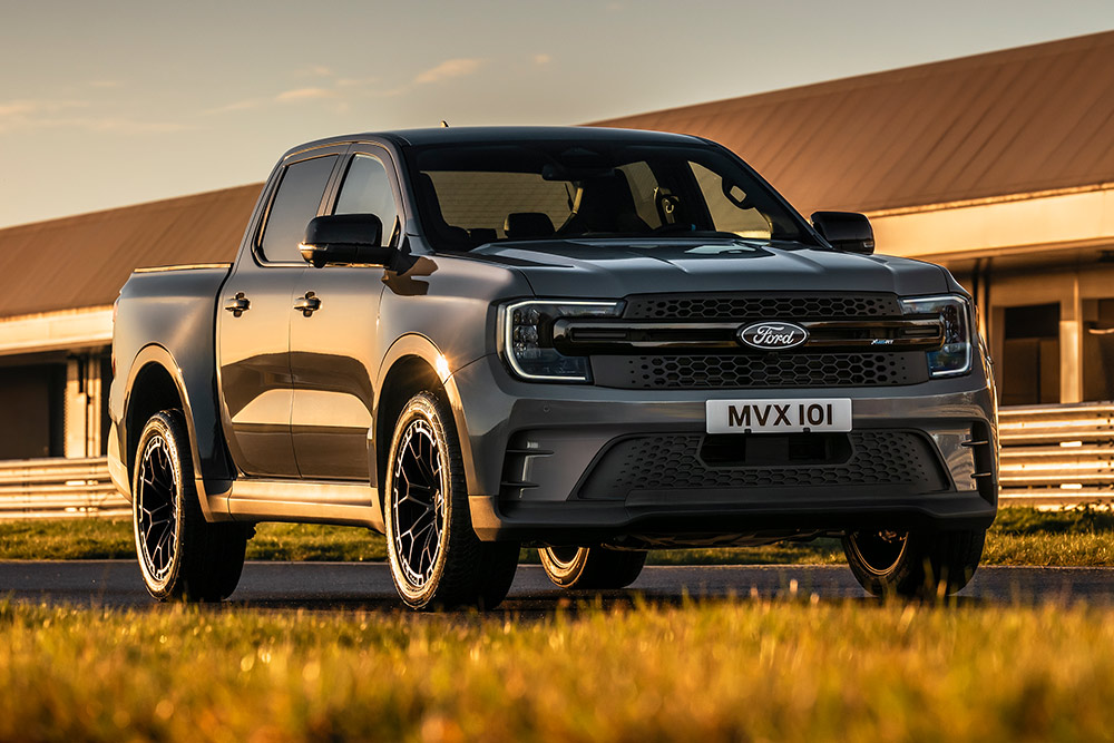 Ford Pro Ranger Híbrido Enchufable plateado aparcado frente a un edificio industrial.