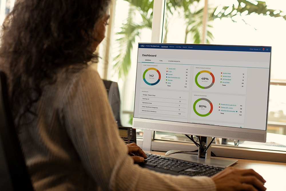 Mujer viendo los datos de su panel de control telemático de Ford en su ordenador de sobremesa.
