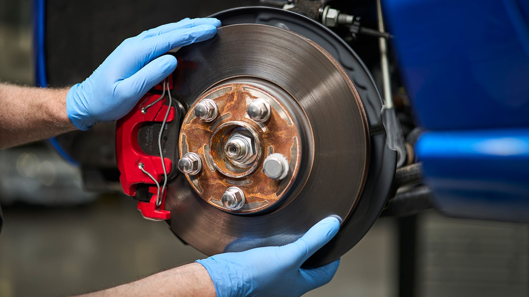 Un mecánico sujetando una pieza original de Ford durante una revisión.