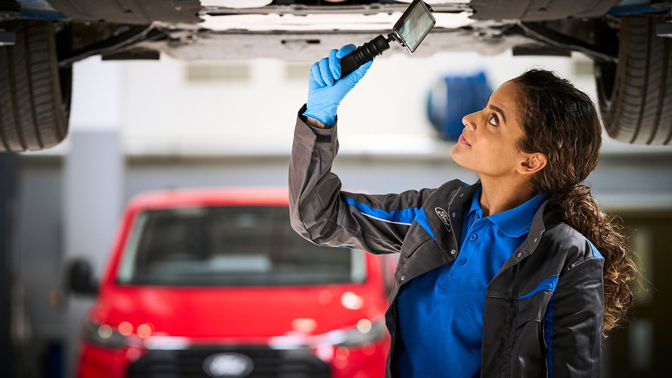 Un mecánico grabando un Ford Video Check durante la revisión de un vehículo. 