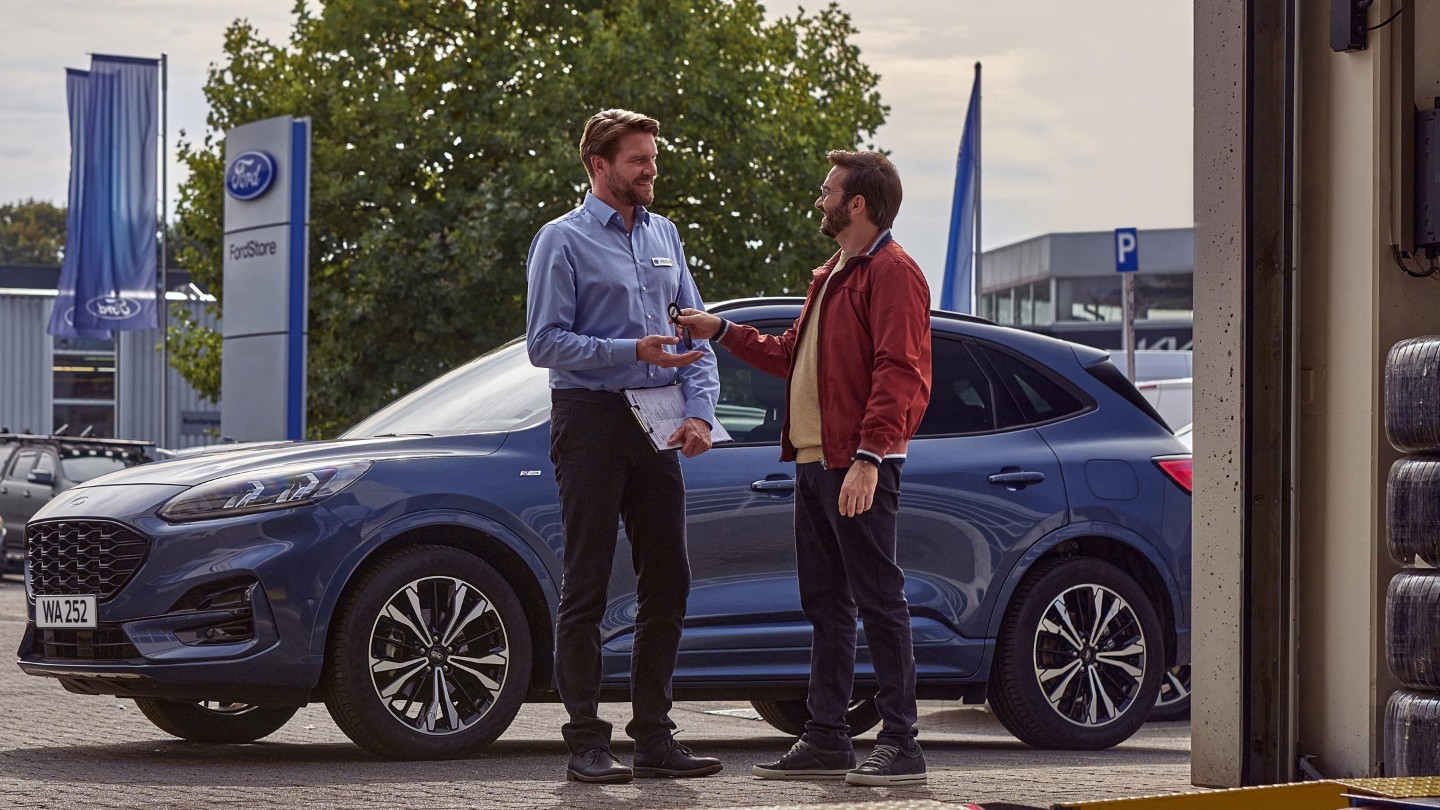 Lady handing keys to Ford veichle to service engineer