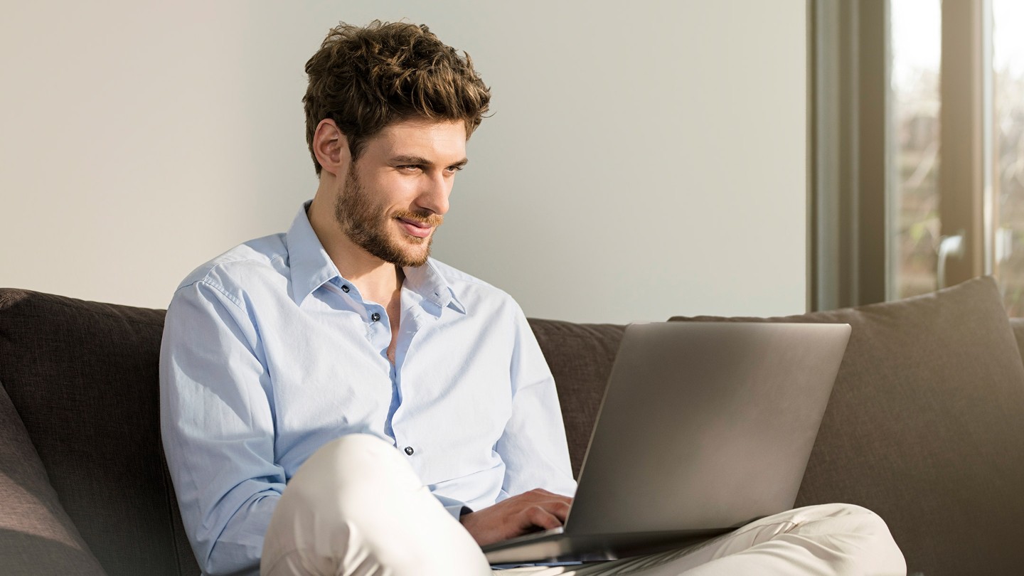 Un hombre con un portátil utilizando la reserva de cita de taller online de Ford