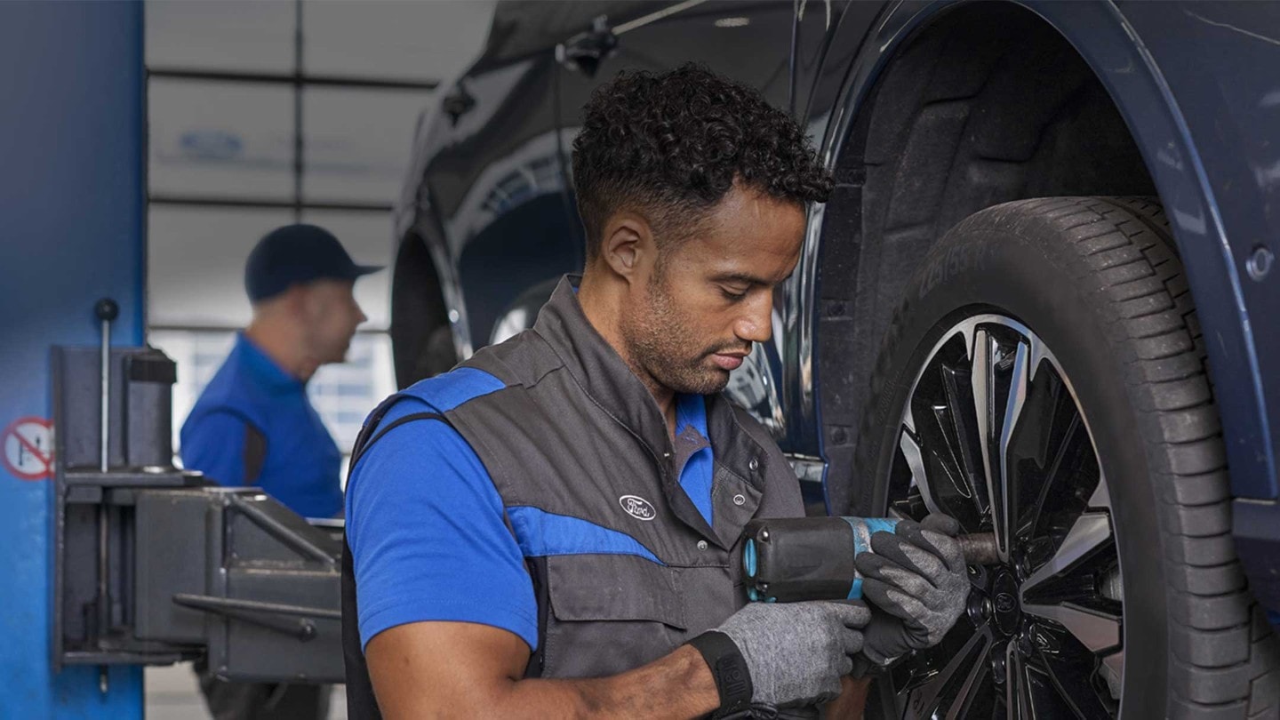 Un técnico de servicio de Ford apretando los pernos de las ruedas